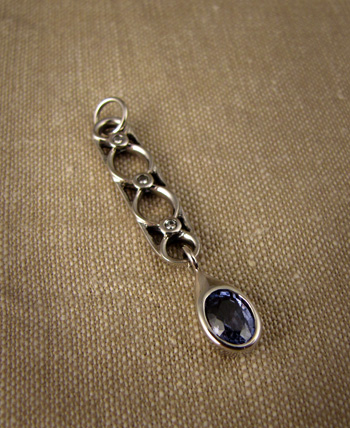 Art Deco-inspired palladium pendant with diamonds and a sapphire drop