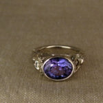 Hand-carved Tanzanite solitaire with poppy motif, 18K