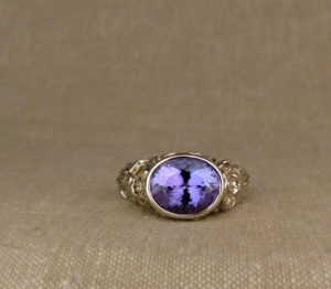 Hand-carved Tanzanite solitaire with poppy motif, 18K