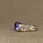 Hand-carved Tanzanite solitaire with poppy motif, 18K