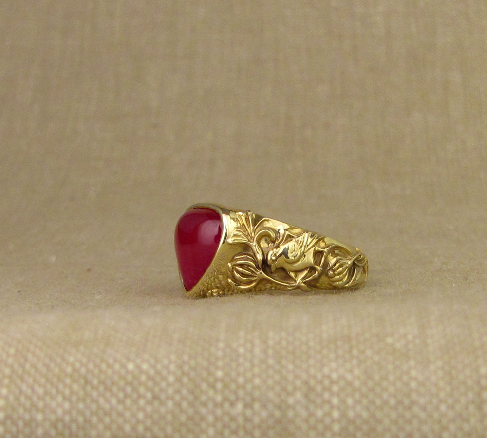 Custom designed & hand carved honeysuckle & bird motif solitaire, cabochon ruby pear, 18K yellow gold