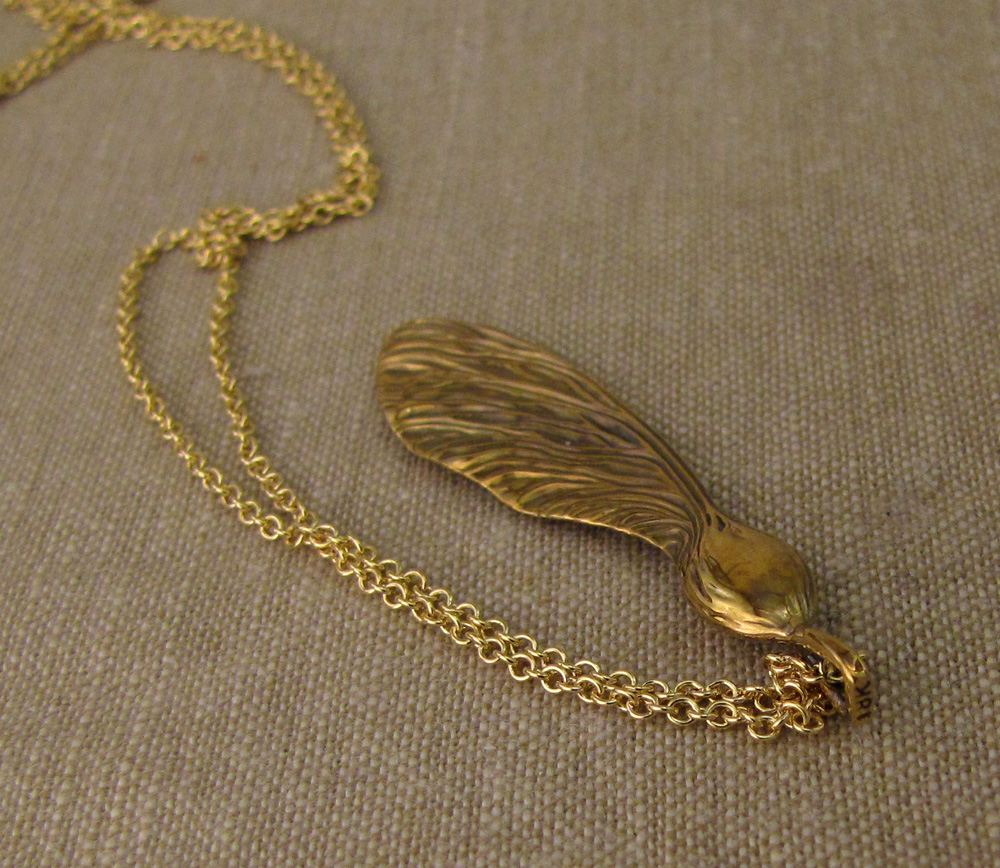 Hand-carved maple/helicopter seed pendant in 18K yellow gold