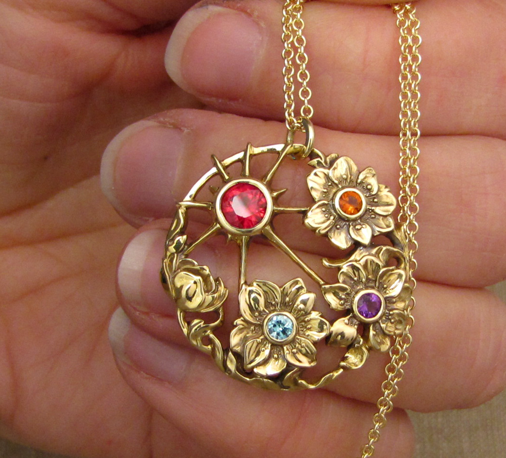 Custom-designed & hand-carved 'Mother's' pendant with ruby, blue zircon, citrine, and amethyst birthstones, in 18K yellow gold.