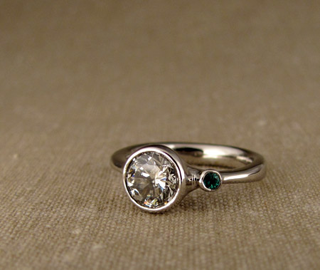 Diamond solitaire with emerald side stone; Palladium