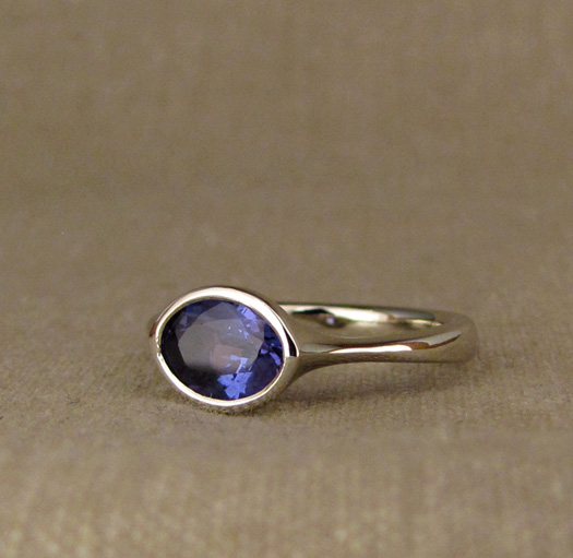Custom Low-Profile Bezel Solitaire with oval tanzanite, 14K white gold