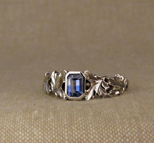Custom designed & hand-carved maple solitaire with bi-color blue sapphire, 14K white gold