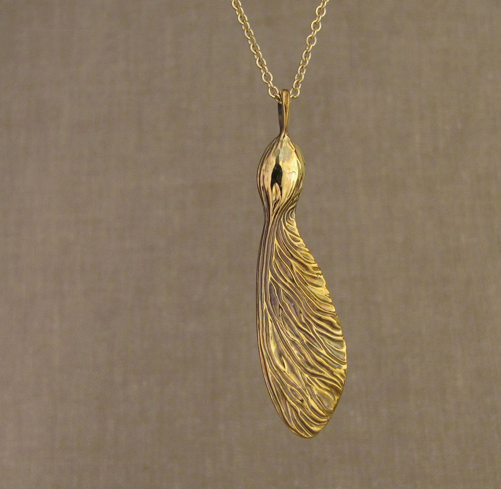 Hand-carved sycamore seed pendant in 18K yellow gold