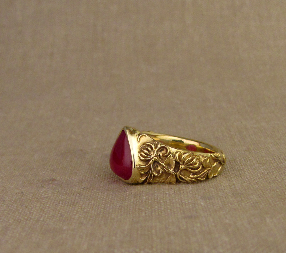 Custom designed & hand carved honeysuckle & bird motif solitaire, cabochon ruby pear, 18K yellow gold