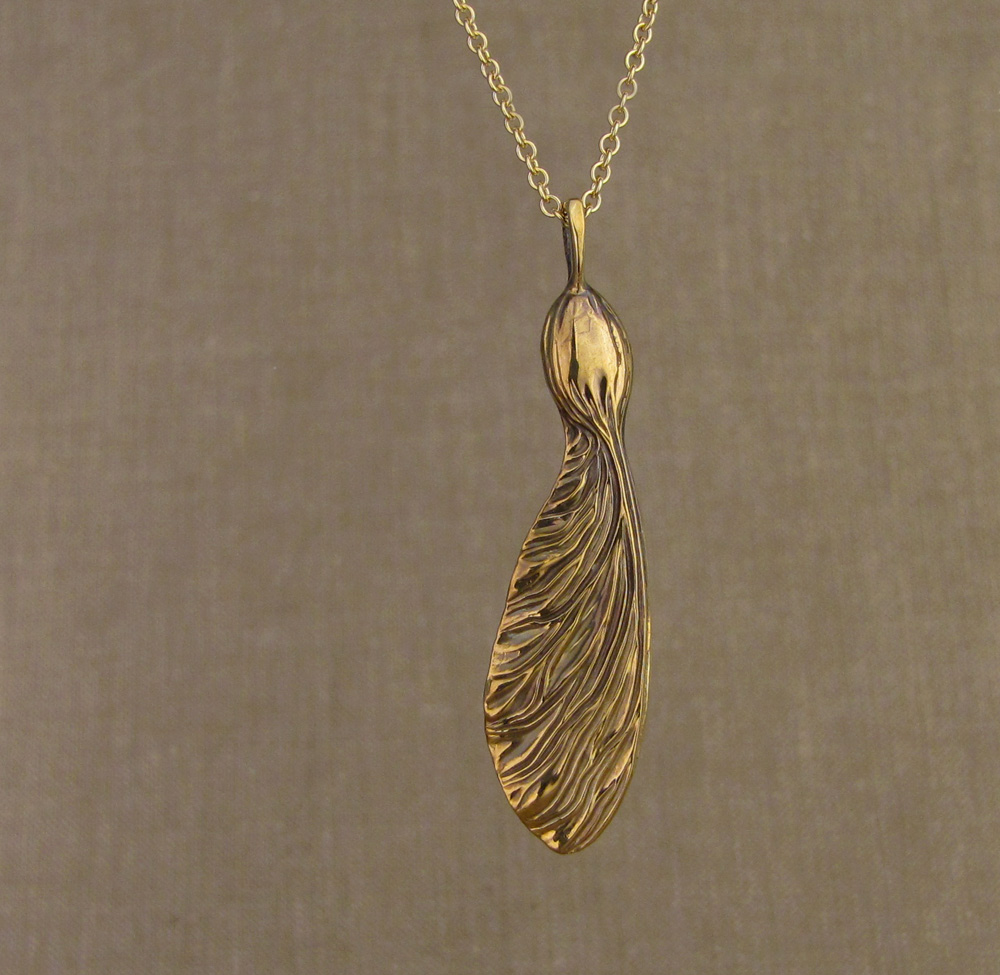 Hand-carved sycamore seed pendant in 18K yellow gold