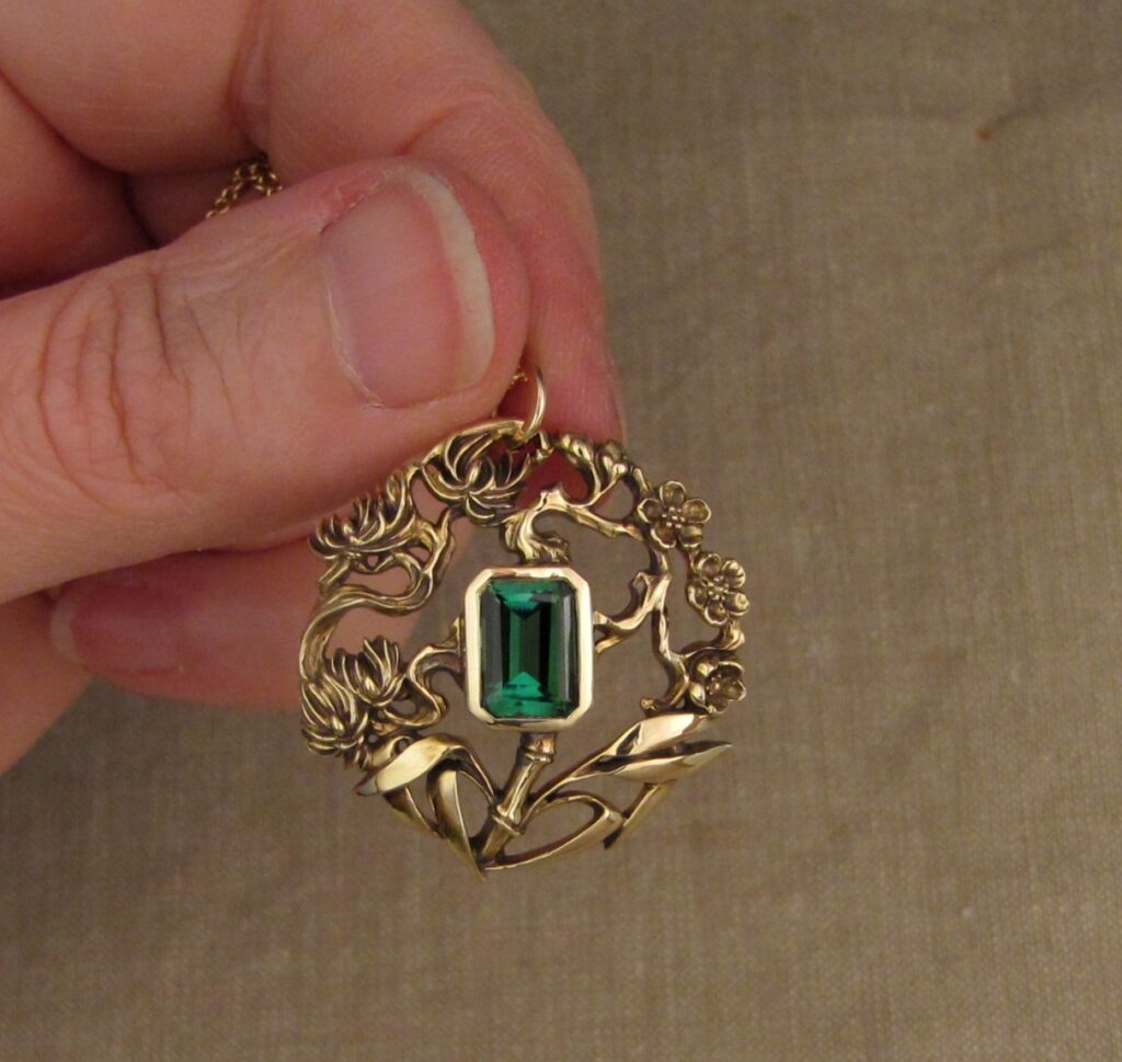 Three friends of Winter pendant (plum, pine, bamboo) hand carved, 14K yellow gold, green tourmaline. Cheyenne Weil