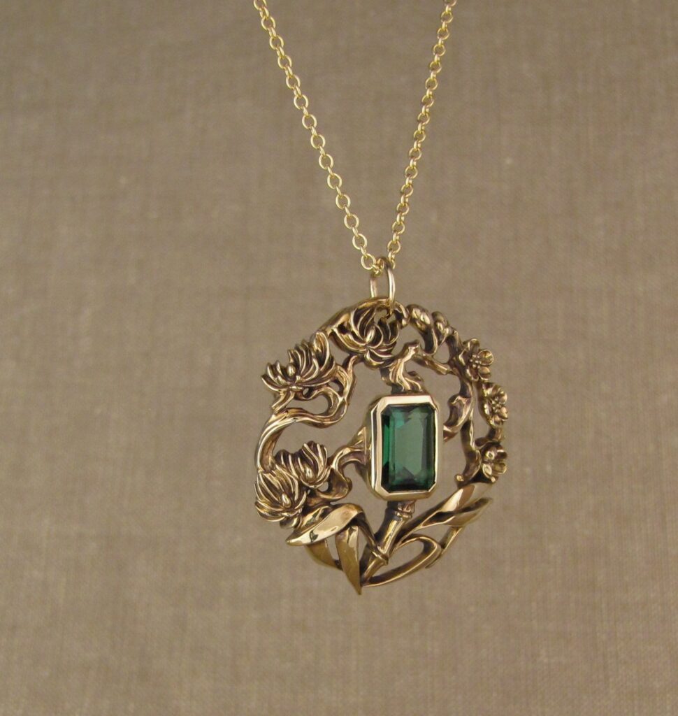 Three friends of Winter pendant (plum, pine, bamboo) hand carved, 14K yellow gold, green tourmaline. Cheyenne Weil