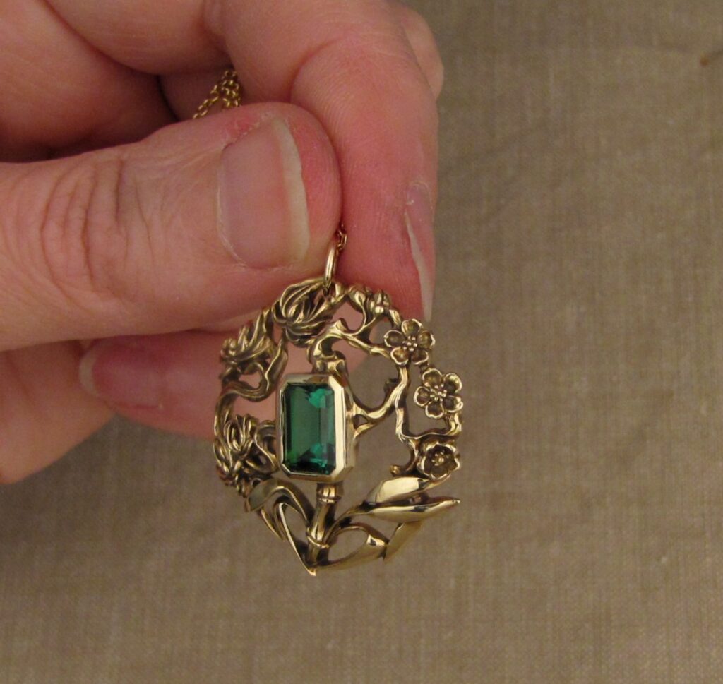 Three friends of Winter pendant (plum, pine, bamboo) hand carved, 14K yellow gold, green tourmaline. Cheyenne Weil
