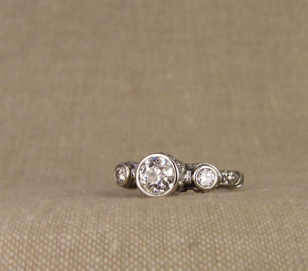 Custom Designed & Hand-carved Three-stone solitaire with antique Old European Cut diamond. Ferns, ivy, pinecones motifs, 14K white gold.