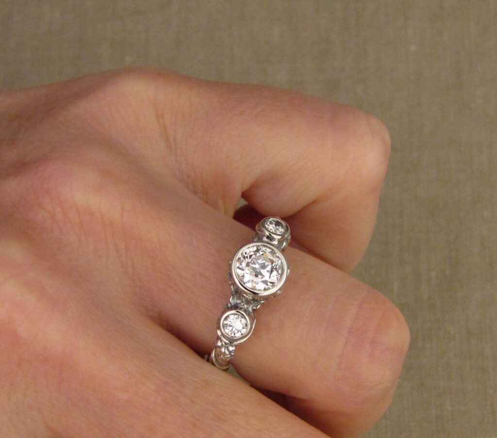 Custom Designed & Hand-carved Three-stone solitaire with antique Old European Cut diamond. Ferns, ivy, pinecones motifs, 14K white gold.