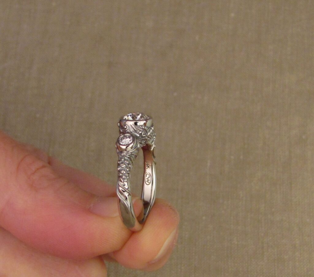 Custom Designed & Hand-carved Three-stone solitaire with antique Old European Cut diamond. Ferns, ivy, pinecones motifs, 14K white gold.