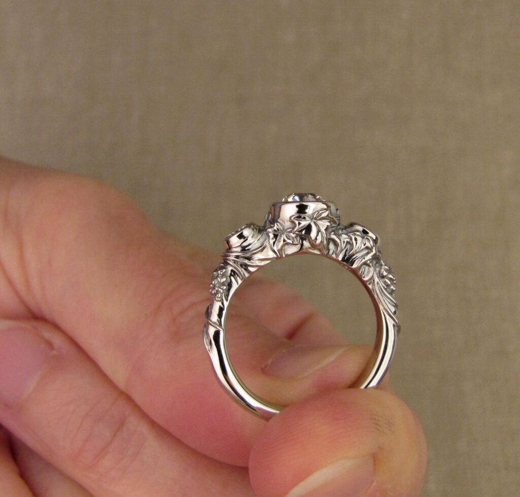 Custom Designed & Hand-carved Three-stone solitaire with antique Old European Cut diamond. Ferns, ivy, pinecones motifs, 14K white gold.