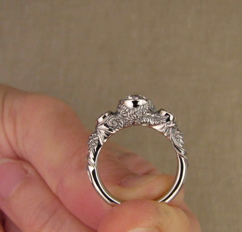 Custom Designed & Hand-carved Three-stone solitaire with antique Old European Cut diamond. Ferns, ivy, pinecones motifs, 14K white gold.