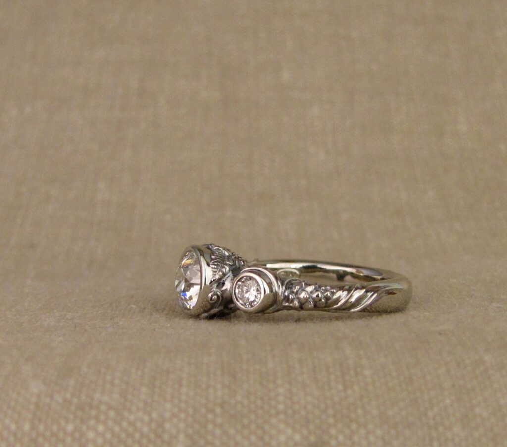 Custom Designed & Hand-carved Three-stone solitaire with antique Old European Cut diamond. Ferns, ivy, pinecones motifs, 14K white gold.