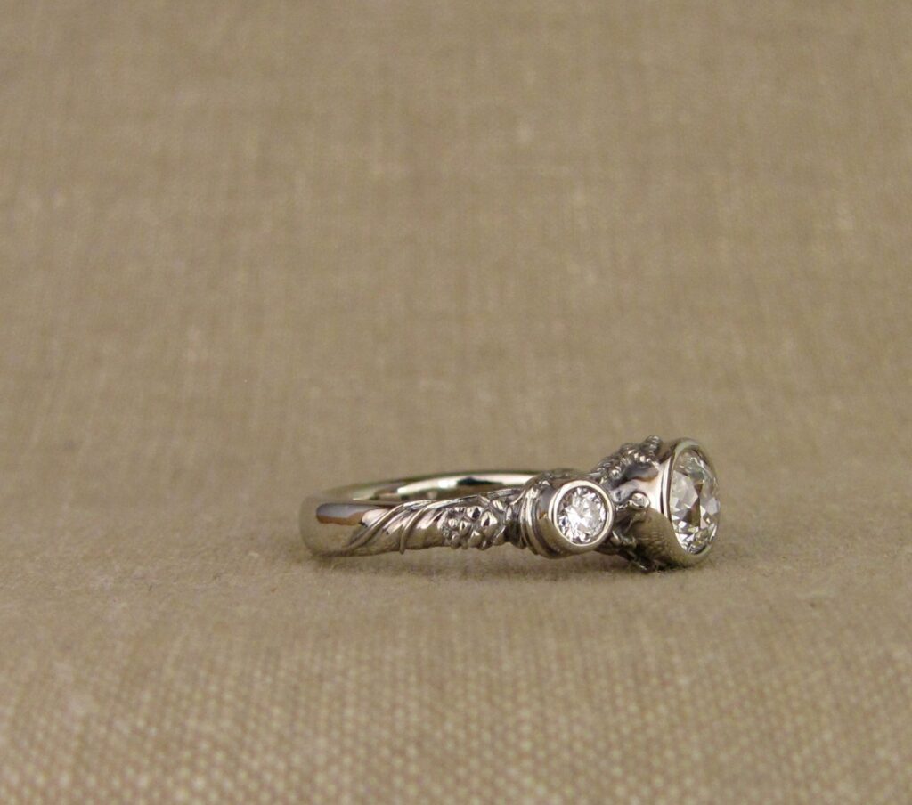 Custom Designed & Hand-carved Three-stone solitaire with antique Old European Cut diamond. Ferns, ivy, pinecones motifs, 14K white gold.