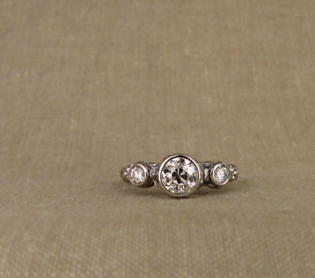 Custom Designed & Hand-carved Three-stone solitaire with antique Old European Cut diamond. Ferns, ivy, pinecones motifs, 14K white gold.