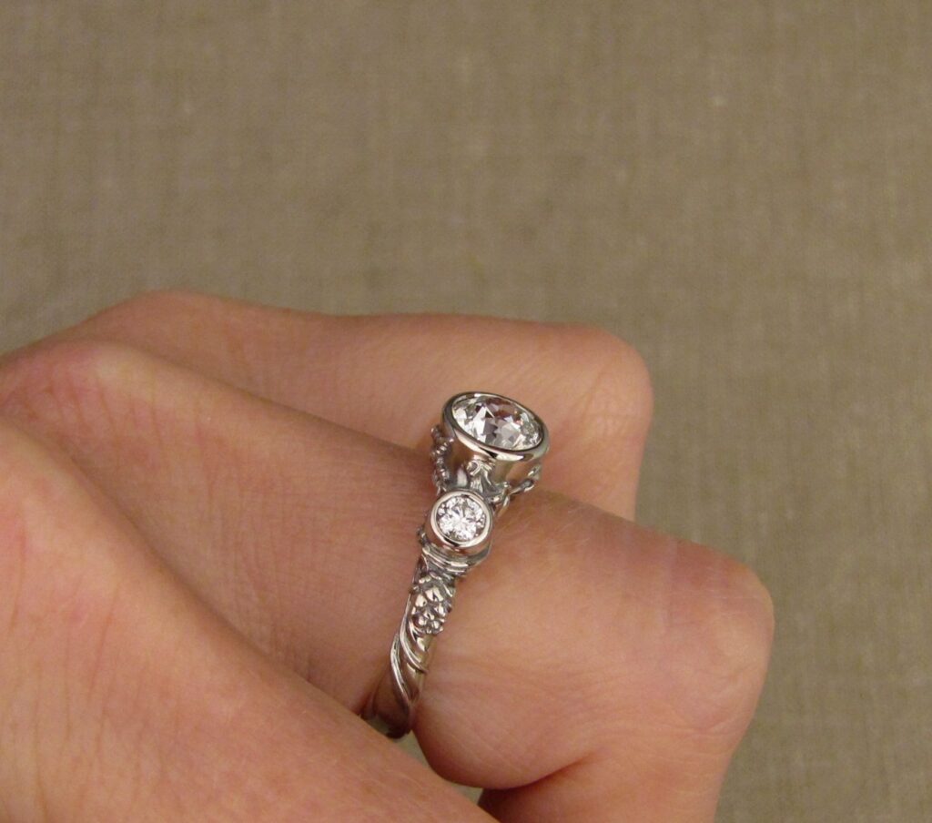 Custom Designed & Hand-carved Three-stone solitaire with antique Old European Cut diamond. Ferns, ivy, pinecones motifs, 14K white gold.