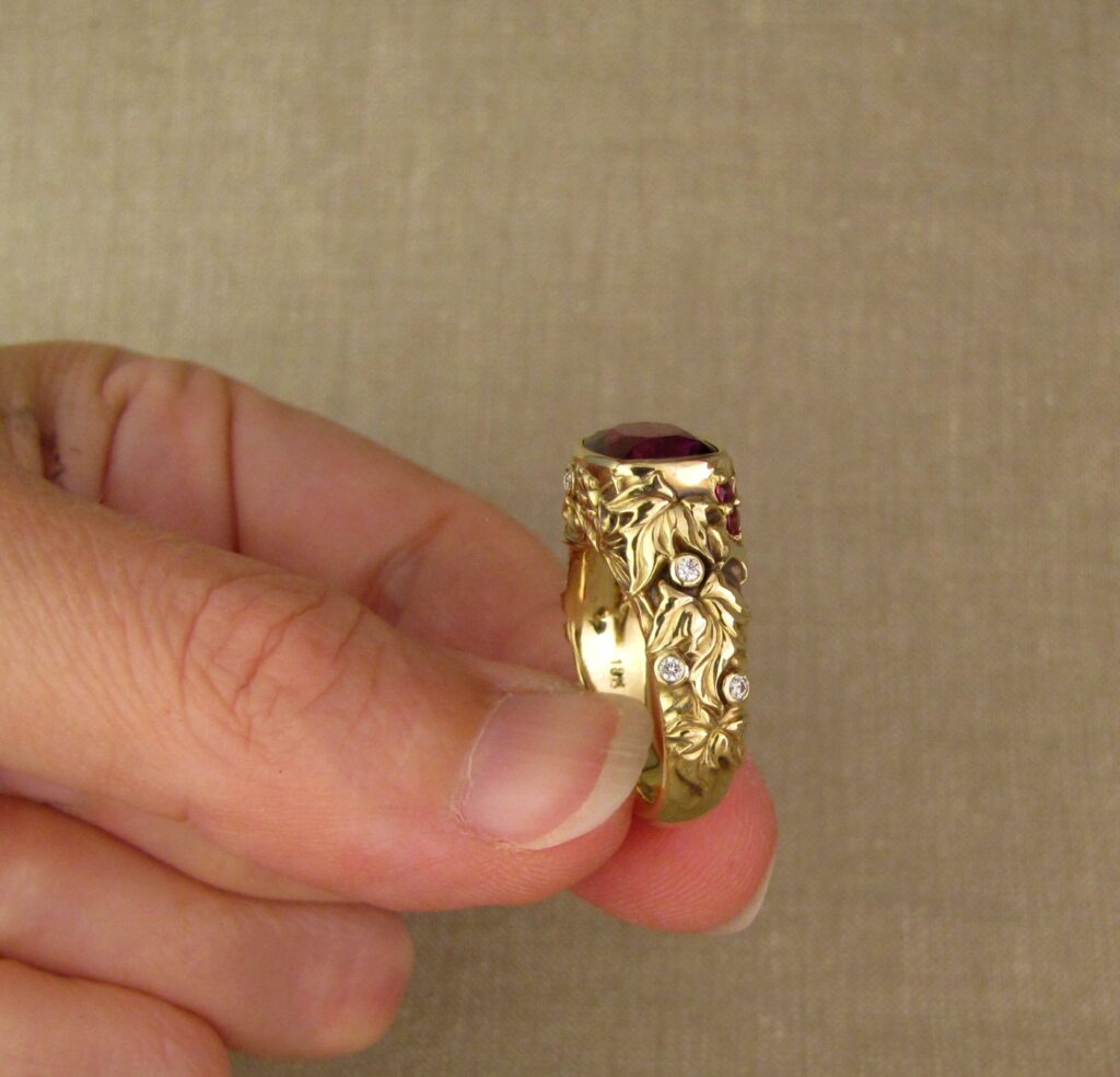 Custom designed & hand-carved Berry-colored garnet, Ivy and Holly Leaves with pine bough motifs, diamonds & multi-colored garnet berries. 18K yellow gold