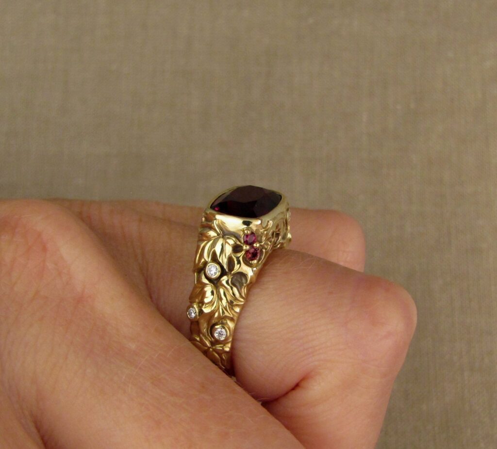 Custom designed & hand-carved Berry-colored garnet, Ivy and Holly Leaves with pine bough motifs, diamonds & multi-colored garnet berries. 18K yellow gold