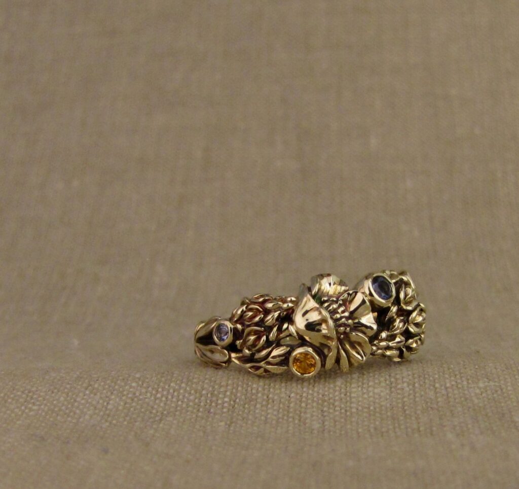 Custom designed & hand-carved California Poppies and Texas Bluebonnets ring in 14K gold with blue sapphires & yellow-orange spessartite garnets. Cheyenne Weil