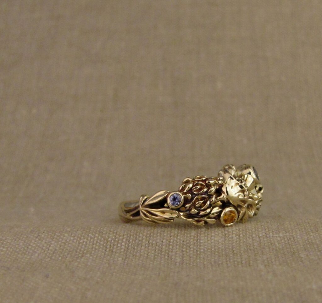 Custom designed & hand-carved California Poppies and Texas Bluebonnets ring in 14K gold with blue sapphires & yellow-orange spessartite garnets. Cheyenne Weil