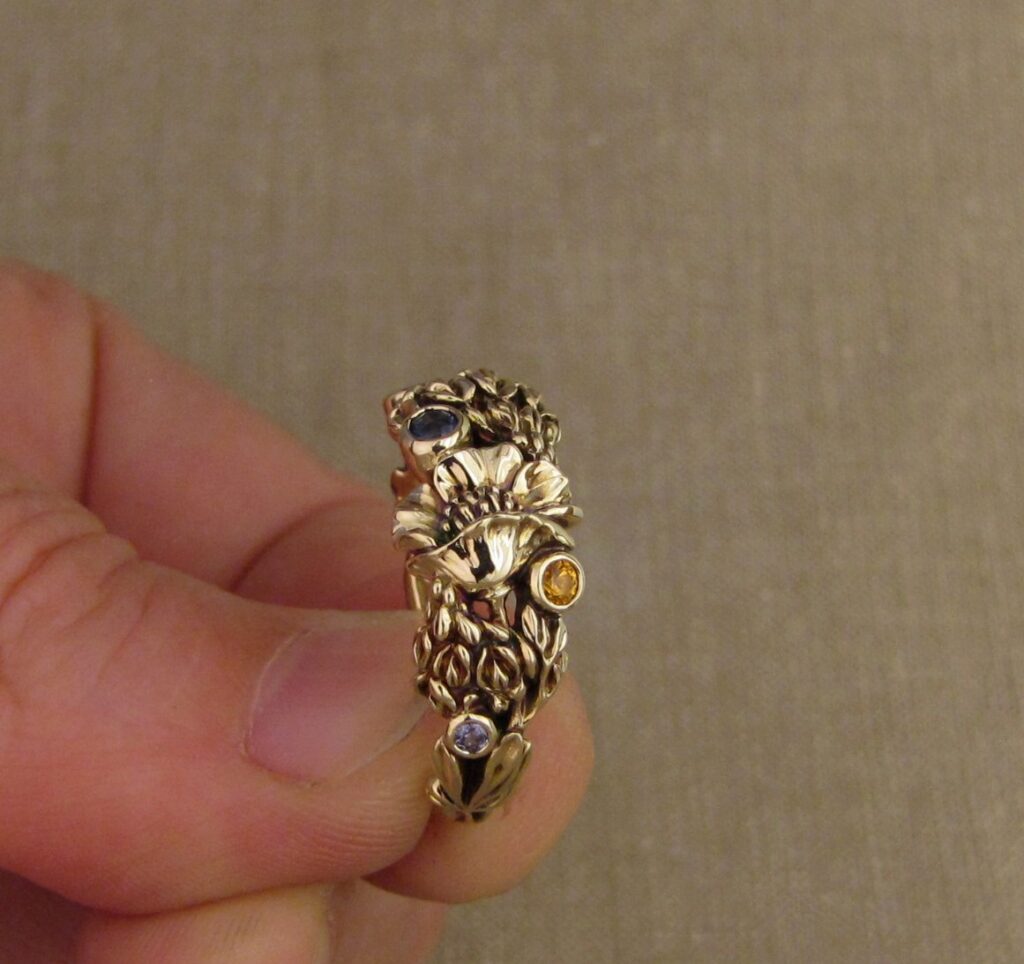 Custom designed & hand-carved California Poppies and Texas Bluebonnets ring in 14K gold with blue sapphires & yellow-orange spessartite garnets. Cheyenne Weil