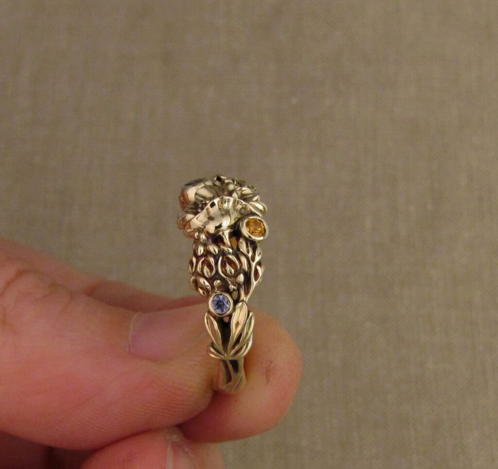 Custom designed & hand-carved California Poppies and Texas Bluebonnets ring in 14K gold with blue sapphires & yellow-orange spessartite garnets. Cheyenne Weil