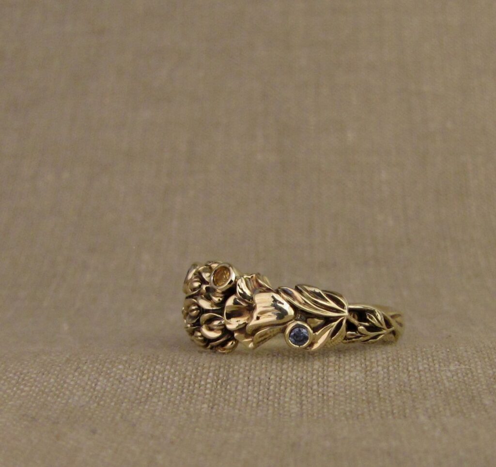 Custom designed & hand-carved California Poppies and Texas Bluebonnets ring in 14K gold with blue sapphires & yellow-orange spessartite garnets. Cheyenne Weil