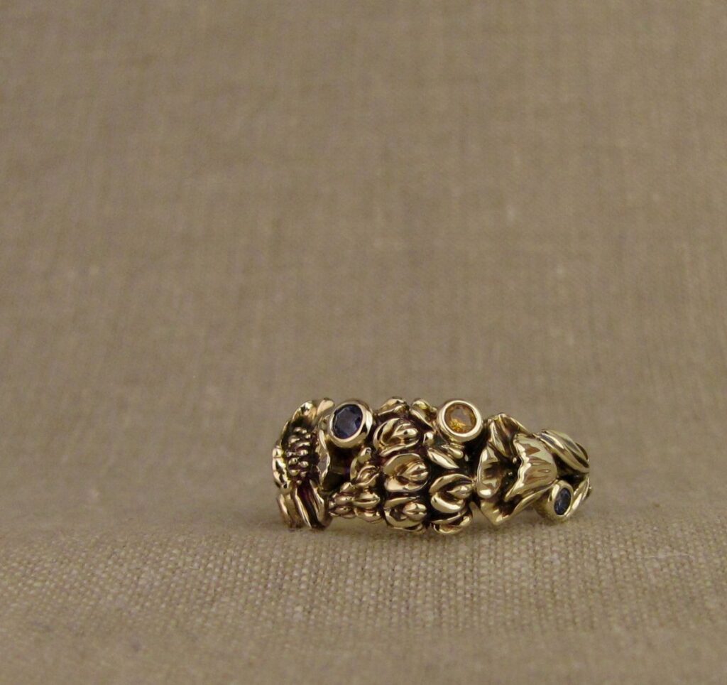 Custom designed & hand-carved California Poppies and Texas Bluebonnets ring in 14K gold with blue sapphires & yellow-orange spessartite garnets. Cheyenne Weil